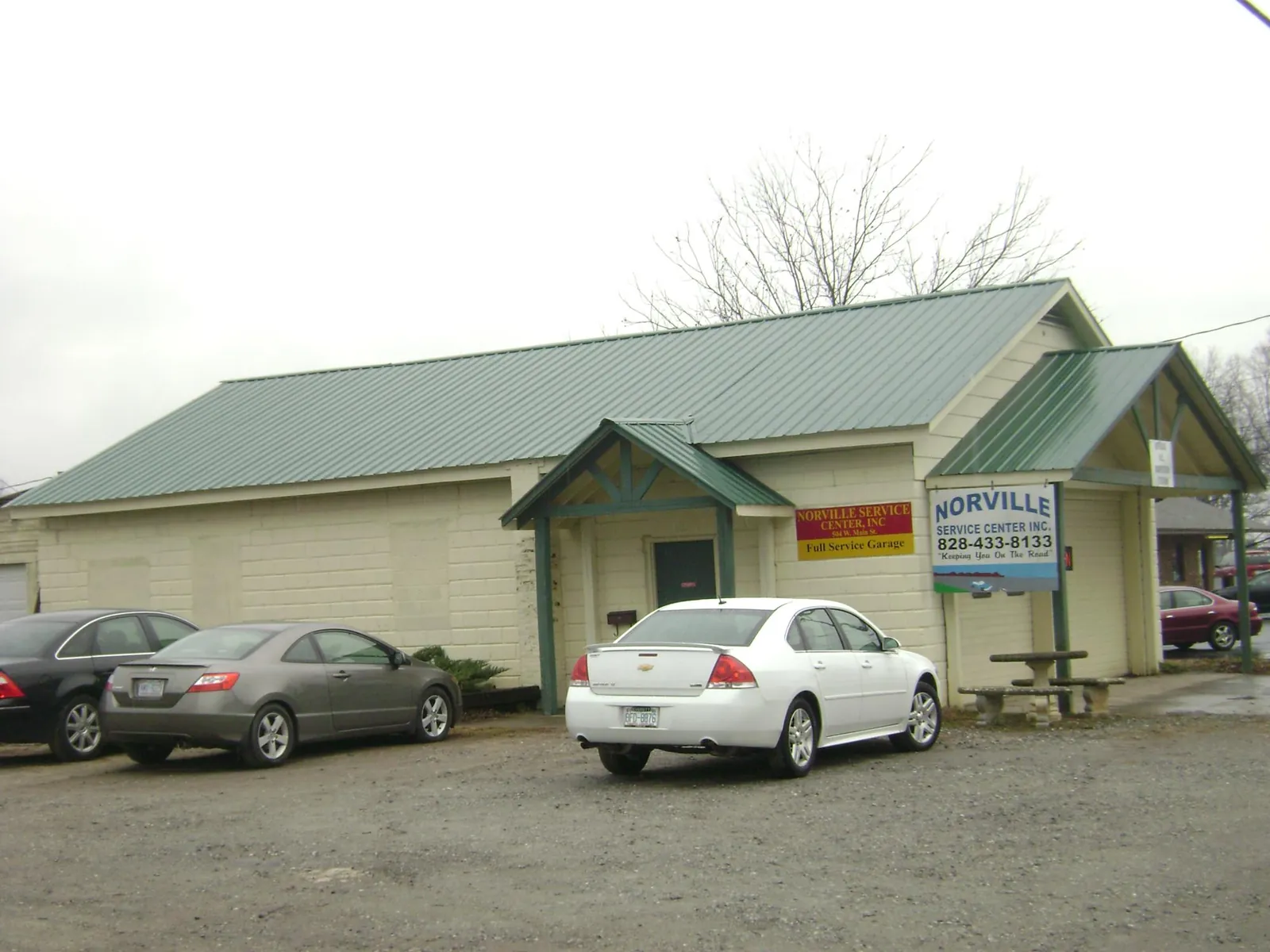 Green metal roof on a service garage with a covered entry in Copperhill
