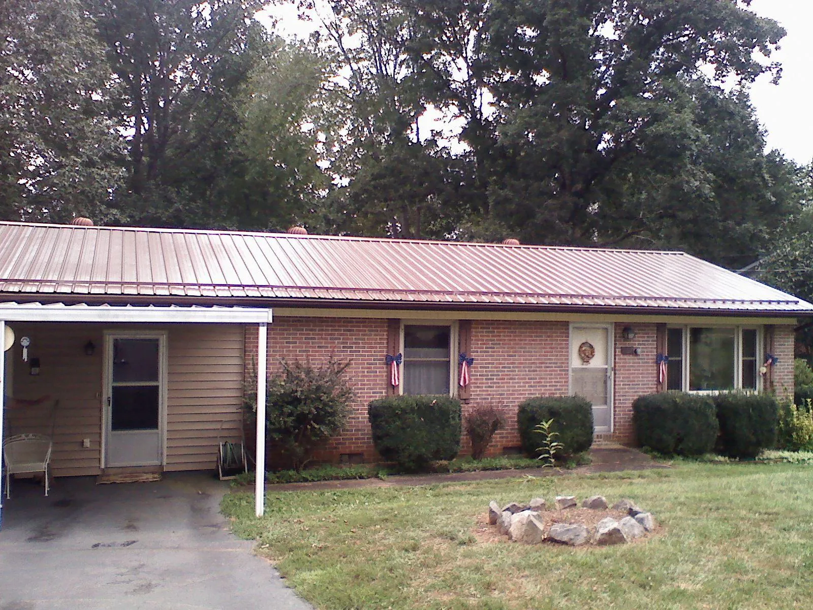 Bronze metal roof and carport on a brick ranch home — Roof Repair work by our crew in Copperhill